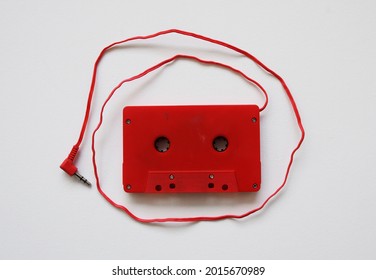 Red Vintage Car Adaptor Tape Deck Cassette With Aux Cable Cord On White Background