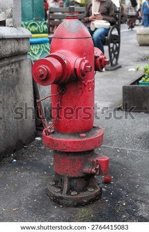 Red vintage fire hydrant on a city sidewalk street background