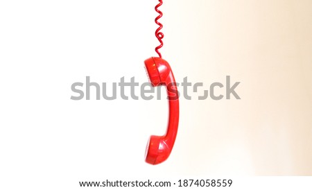 Red vintage phone off the hook on a white background