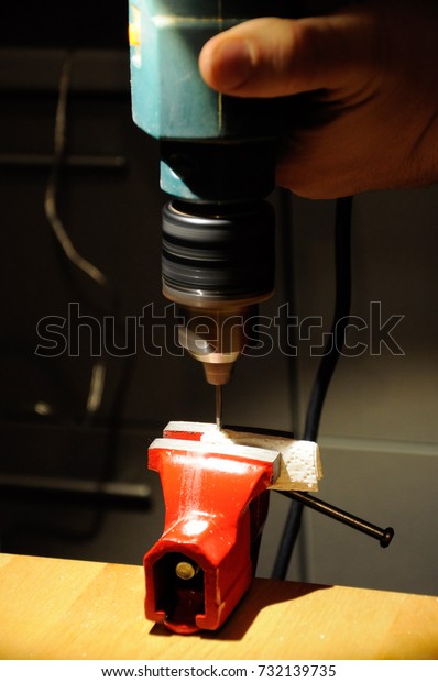Red vise and hands of handy man working in\
workshop with workbench\
