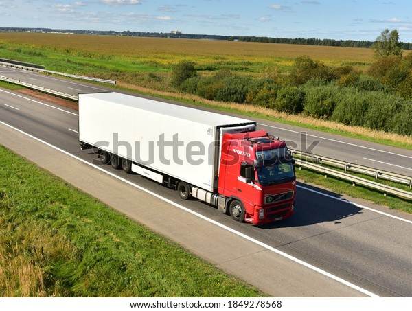 Red VOLVO FH refrigerator truck with Semi-trailer\
driving on highway. Goods Delivery by roads. Services and Transport\
logistics Out of focus, possible granularity. RUSSIA, MOSCOW - SEPT\
12, 2020\
