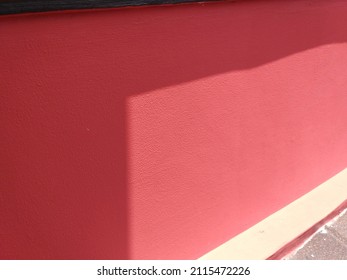 Red wall with sun shadow background