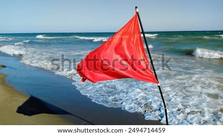 Red warning flag on the beach .Danger to swim in sea