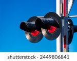 Red warning lights at an American railroad crossing in Arizona. Flashing lights from a worm