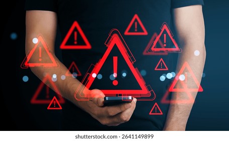 Red warning sign icons with exclamation marks over smartphone in male hand, glowing on dark background, concept of digital alert and cyber threat