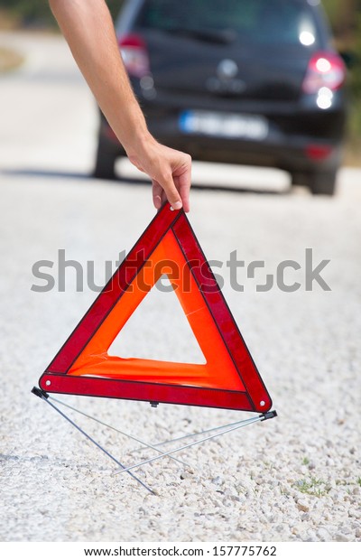 Red warning\
triangle with a broken down\
car
