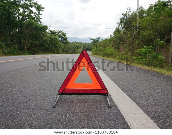 Red\
warning triangle on the road sign with cloudy\
day