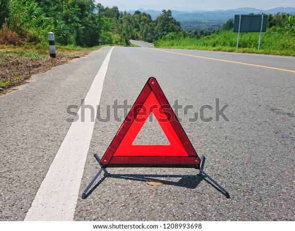 Red\
warning triangle on the road sign with cloudy\
day
