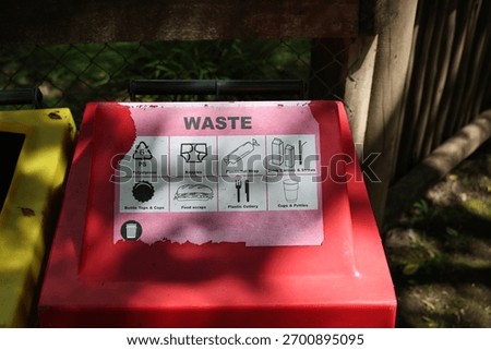 Red waste bin with sorting sign
