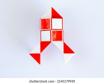red and white bicolor magic snake Transformable twist puzzle in shape of space rocket isolated on white background. it develops spatial thinking.