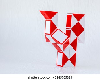red and white bicolor magic snake Transformable twist puzzle in shape of cock isolated on white background. it develops spatial thinking.