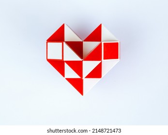 red and white bicolor magic snake Transformable twist puzzle in shape of heart isolated on white background. it develops spatial thinking. version 2
