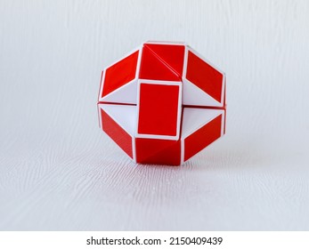red and white bicolor magic snake Transformable twist puzzle in shape of ball isolated on white background. it develops spatial thinking.
