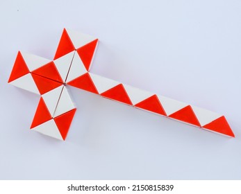 red and white bicolor magic snake Transformable twist puzzle in shape of knight sword isolated on white background. it develops spatial thinking.