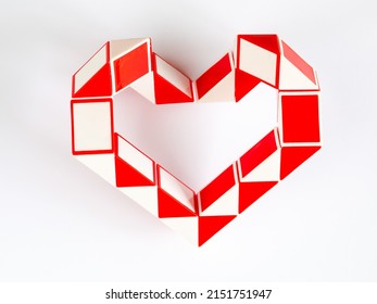 red and white bicolor magic snake Transformable twist puzzle in shape of heart isolated on white background. it develops spatial thinking. version 1