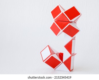 red and white bicolor magic snake Transformable twist puzzle in shape of flower isolated on white background. it develops spatial thinking. version 2