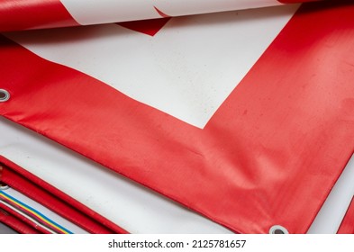 A red and white billboard. PVC fabric folded. Banner with eyelets. Selective focus. - Shutterstock ID 2125781657