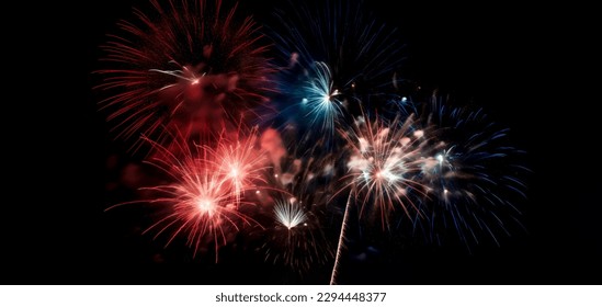 Red, white, and blue fireworks light up the night sky, patriotic celebration, New Years Eve or Independence Day. Shallow depth of field.  - Shutterstock ID 2294448377