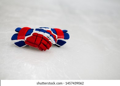 Red, White, and Blue Hockey Gloves on Ice
