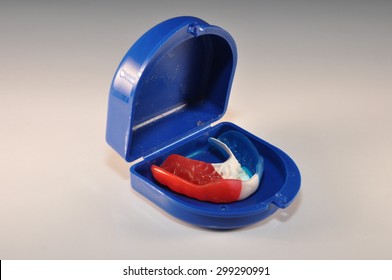 Red White And Blue Mouth Guard And Blue Case On A White Background 