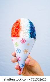 Red, White And Blue Snow Cone In Paper Cone And Blue Straw Held By Female Hands.