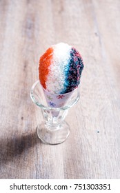 Red, White And Blue Snow Cone In Paper Cone And Blue Straw Held By Female Hands.