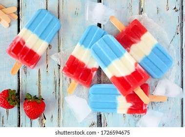Red, White And Blue Summer Fruit Popsicles. Top View Table Scene On A Rustic Blue Wood Background.