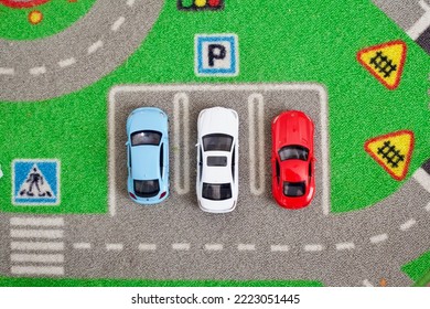 Red, White, And Blue Toy Cars Lined Up On A Parking Lot