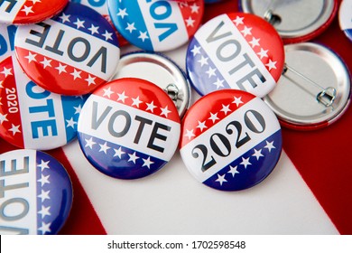 Red, White, And Blue Vote Buttons On Background With American Flag, Elections 2020