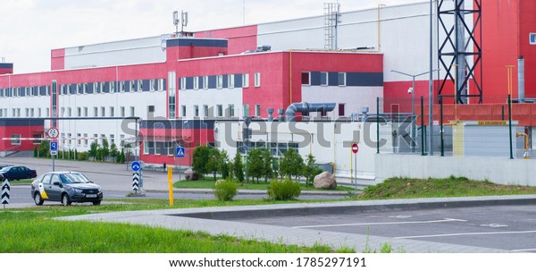 Red white building logistics center\
with cars in the parking. 26 July 2020 Minsk\
Belarus