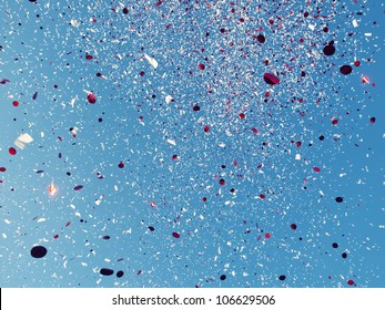 Red And White Confetti Against A Blue Sky