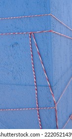 Red And White Cord Tied In Blue Stucco Pillar