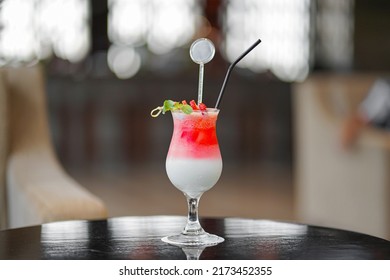 Red And White Drink, With Red Fruit Garnish. Set On A Dark And Shiny Table.