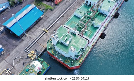 Red And White Floating Storage And Regasification Unit, FSRU, LNG-vessel In Benoa Harbour Under Light Blue Sky.