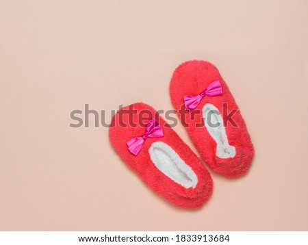 Red and white fur Slippers on a pink background. Comfortable shoes for home.