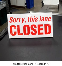 Red and white grocery store checkout lane sign: SORRY, THIS LANE CLOSED.