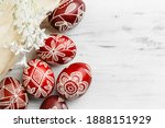 Red and white handmade Easter eggs. Ukrainian pysanka decorated with wax-resist dyeing technique. White wooden background with copy space for text