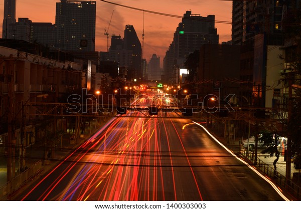 Red and white light streak of driving car on a\
street in Bangkok city,\
Thailand