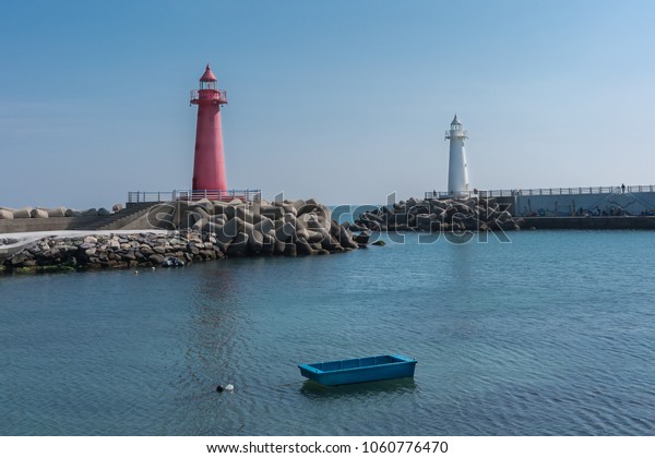Red\
and white  lighthouses marking entry to small\
harbor