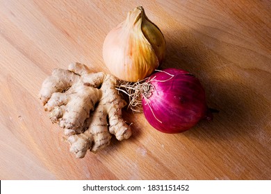 Red And White Onions And Ginger Rot On Wooden Bacgkground