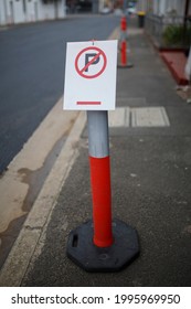 Red And White, Parking Sign On A Post In A Street Side Walk 