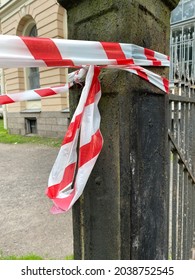 Red And White Polypropylene Signal Tape On An Old Cast Iron Fence Post