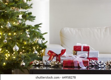 Red And White Presents By Christmas Tree In Modern Living Room