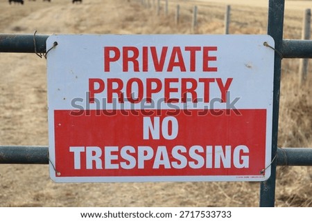 A red and white rectangle sign stating, Private property, and No Trespassing. Mounted to a steel gate warning visitors.