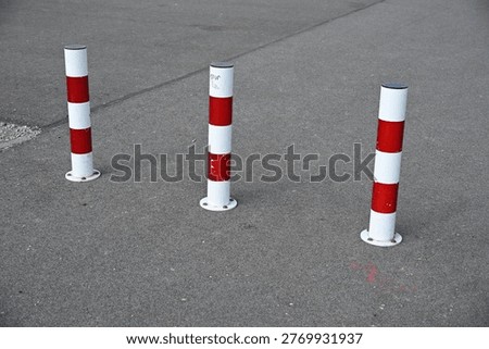 Red and White Road Delineator Posts with Green Field in Background

