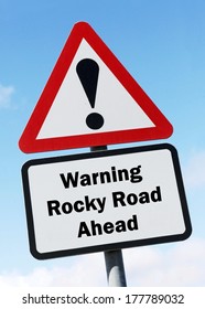 Red And White Road Sign Depicting A Warning About A Rocky Road Ahead. 