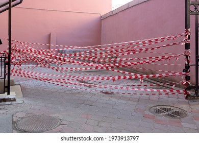 Red And White Safety Tape In The Street Corner. No Trespassing, Do Not Cross Area. Barrier Fencing Tape