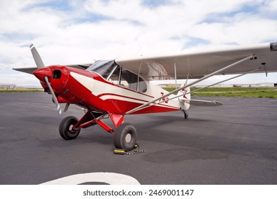 A Red and White Single Engine Airplane on Airport Tarmac - Powered by Shutterstock