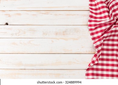 Red and white tablecloth on white wooden table
