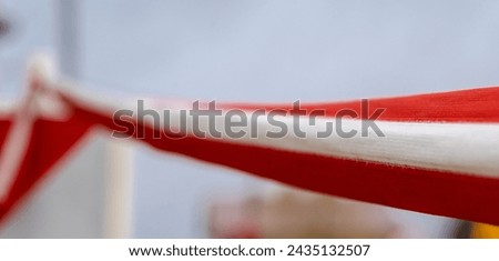 Red and white tape warning against excavations on a construction site.Construction warning tape in bright colors - meaning: 